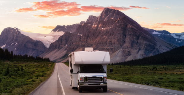 Un VR blanc sur une route panoramique dans les Rocheuses canadiennes au lever du soleil par un jour d’été avec les montagnes en arrière-plan. 
